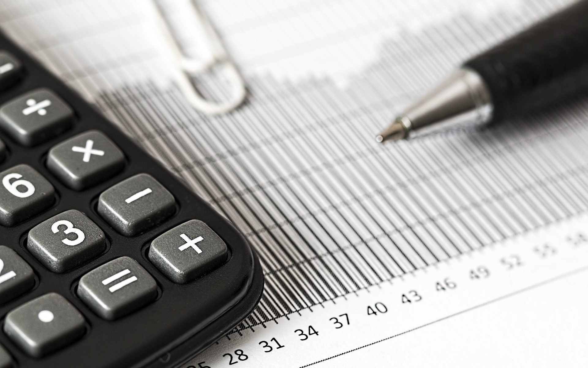 Calculator, pen and financial ledger